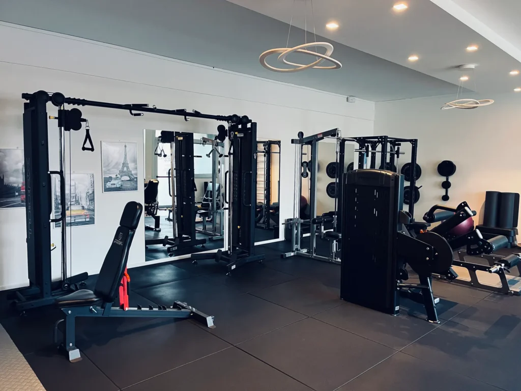 Zona allenamento funzionale con cavi, panca e specchi nello Studio La Fenice
